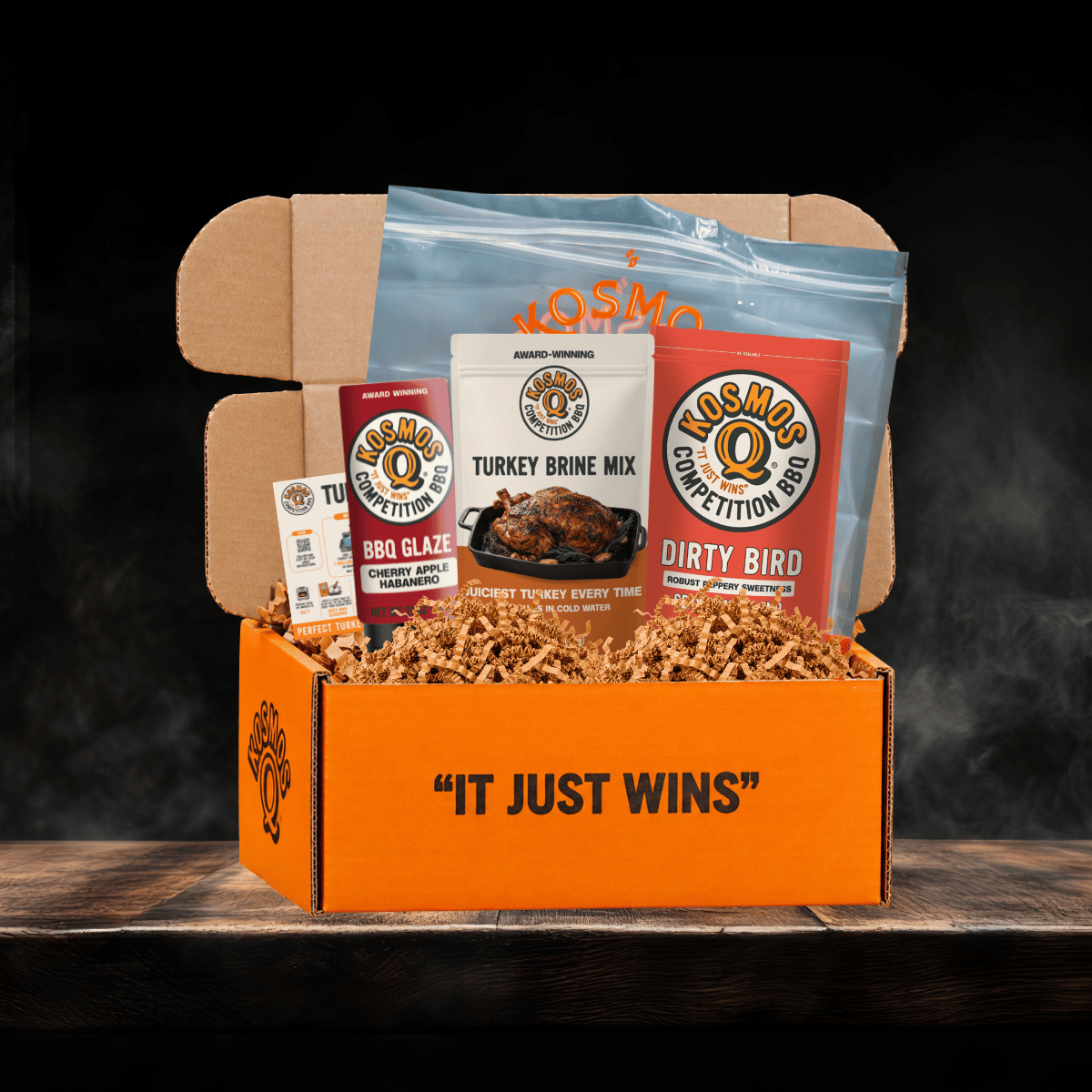 Kosmos Q Complete Turkey Brine kit with turkey brine, dirty bird seasoning blend, cherry apple habanero bbq glaze, a recipe card, and a brining bag in an orange box that says it just wins
